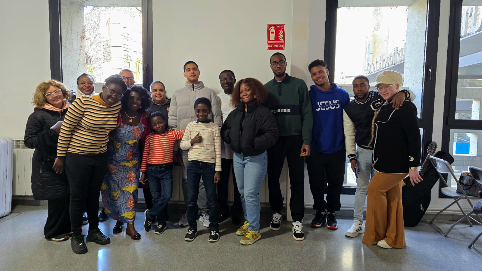 Monochrome handsome unshaven African American male in black suit praying with hands clasped under chin
